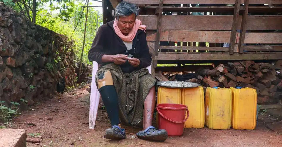 مزارع ميانماري يدعى "هلا هان" بترت ساقه جراء انفجار لغم أرضي يجلس خارج منزله بولاية "كاياه" (صورة:AFP)