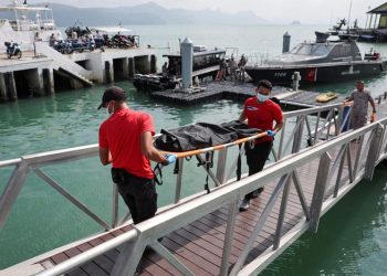 انتشال جثة بعد غرق قارب الروهينجا في المياه القريبة من الحدود التايلاندية الماليزية (صورة: REUTERS)